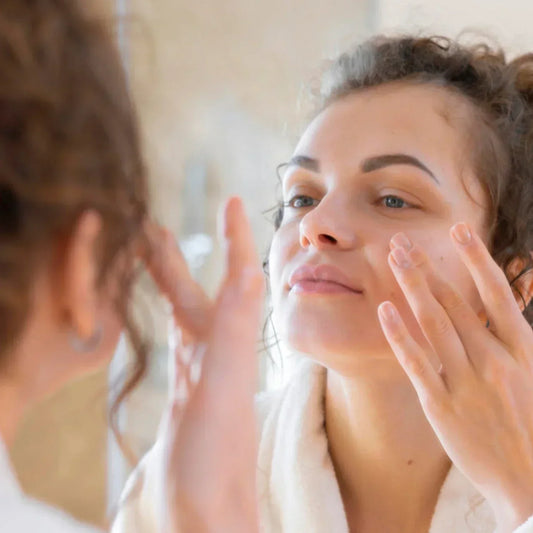Femme appliquant un soin visage, routine peau grasse et peau mixte avec niacinamide.