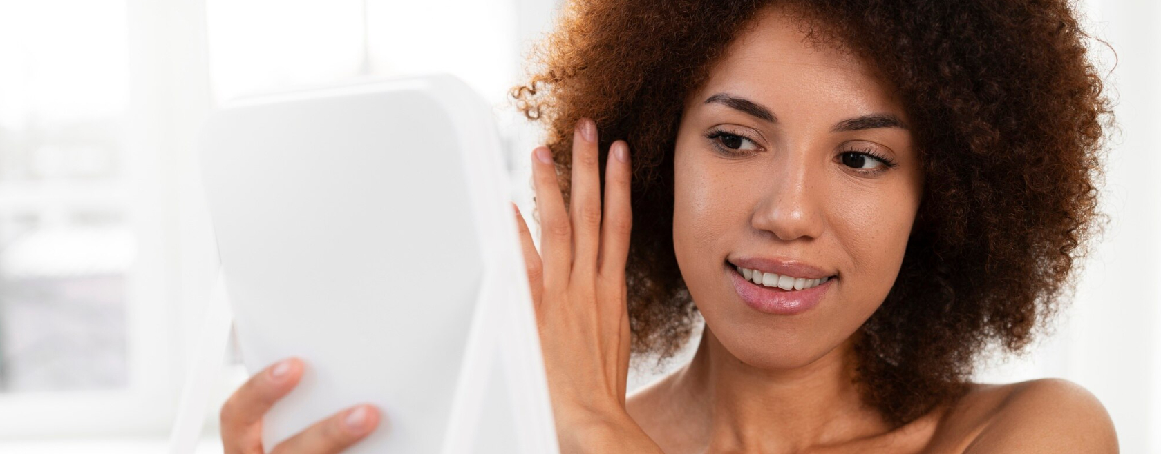 Femme devant un miroir, peau qui brille mais sensation de tiraillement, sujet déshydratation de la peau.