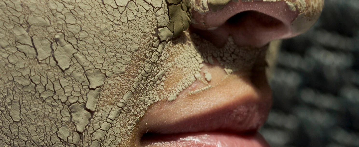 Gros plan d’un visage avec effet craquelé, métaphore de déshydratation de la peau, sensation de tiraillement même quand la peau brille.