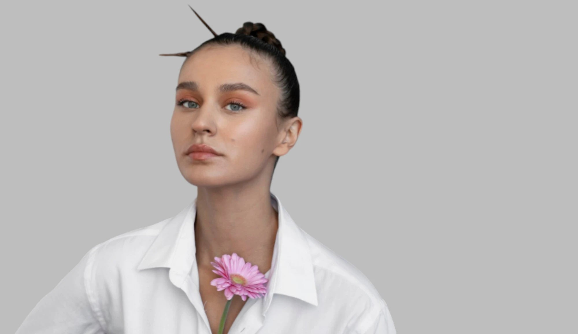 Portrait d’une femme avec une fleur, visuel editorial sur parfum, huiles essentielles et allergènes en cosmétique.