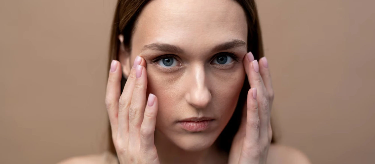 Femme touchant le contour des yeux, illustration des poches sous les yeux et cernes sous les yeux.
