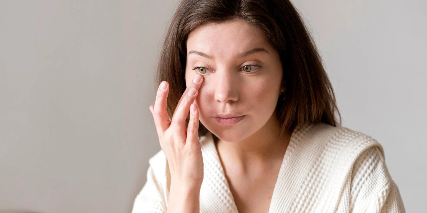 Femme appliquant un soin contour des yeux, poches sous les yeux et cernes sous les yeux.