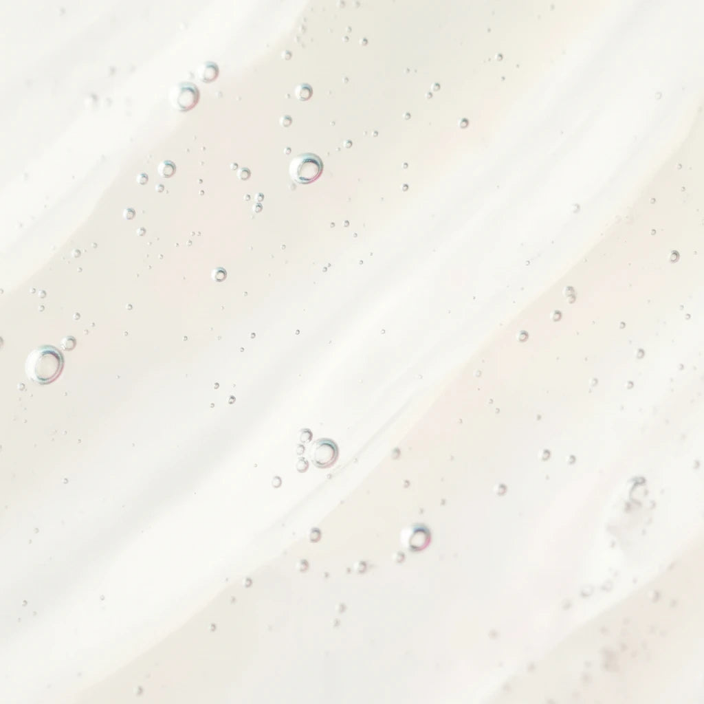 Texture gel transparente avec micro-bulles, illustration du niacinamide (vitamine B3) connu pour aider à équilibrer la peau et améliorer l’apparence d’un teint plus uniforme.