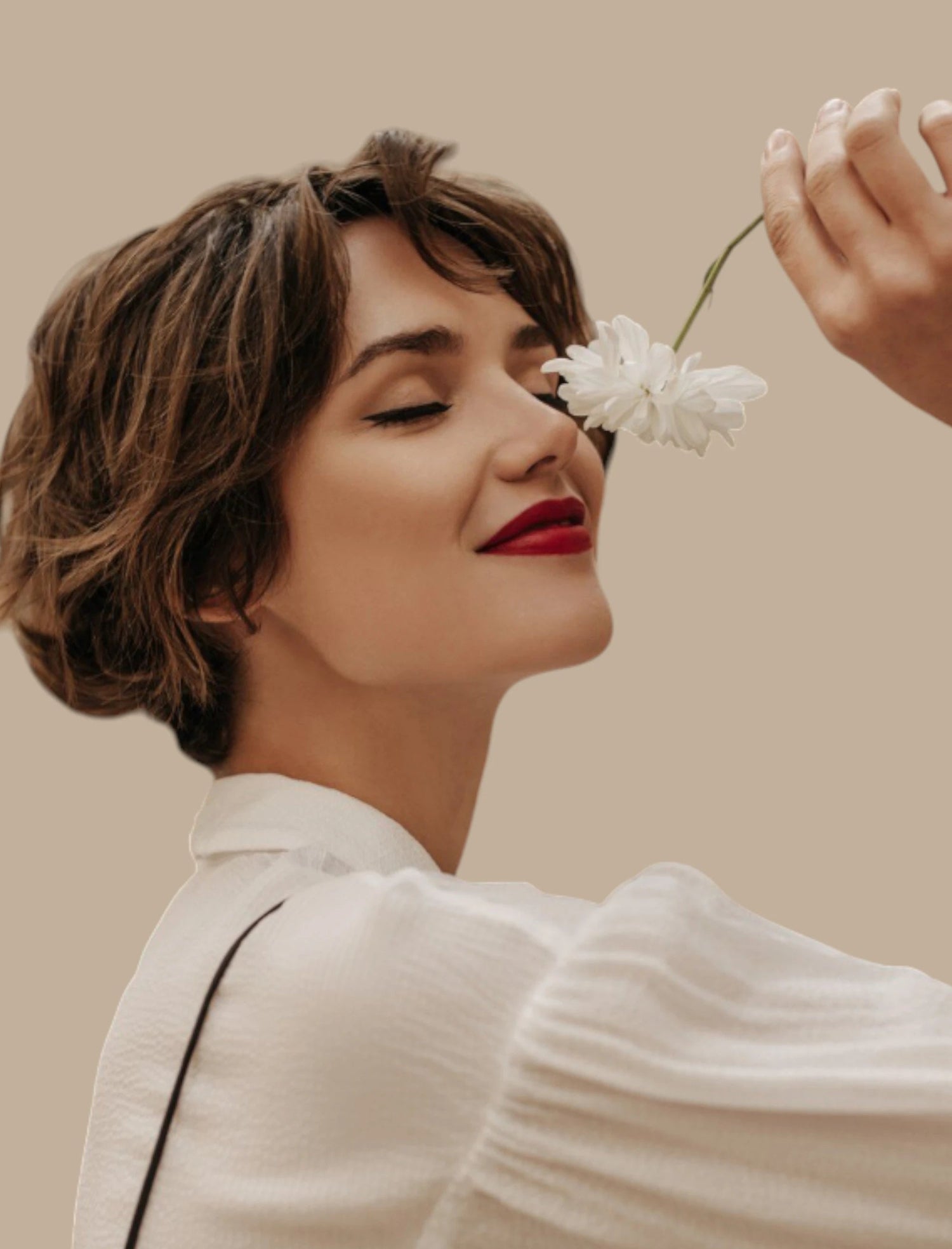 Portrait lifestyle d’une femme sentant une fleur : visuel pour illustrer le parfum et les allergènes, avec une approche de transparence olfactive et de tolérance maîtrisée au quotidien.