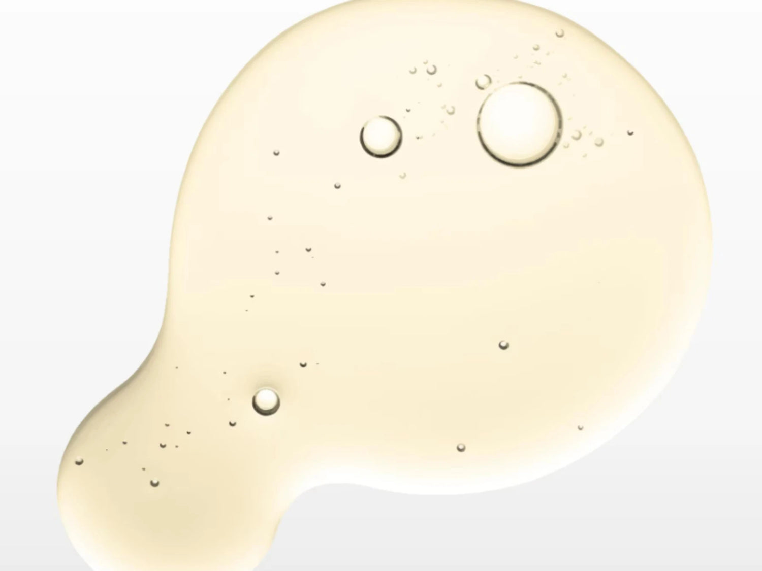 Texture huileuse du sérum Seomse au bakuchiol, alternative au rétinol, avec vitamine E et huile de jojoba, gouttes en macro sur fond blanc