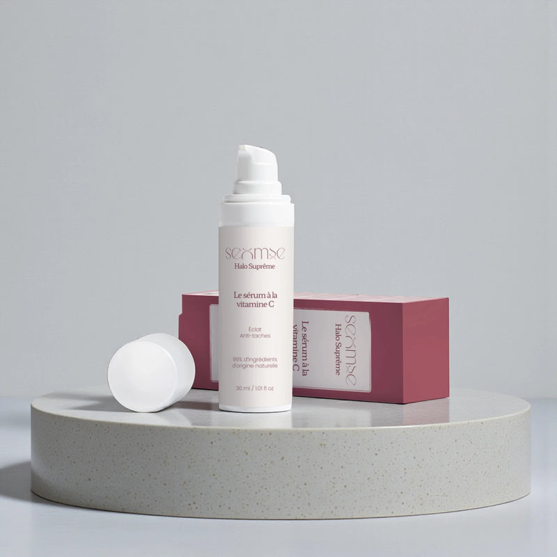 Packshot du sérum vitamine C Seomse Halo Suprême 30 ml, flacon pompe avec étui sur socle, fond gris neutre.