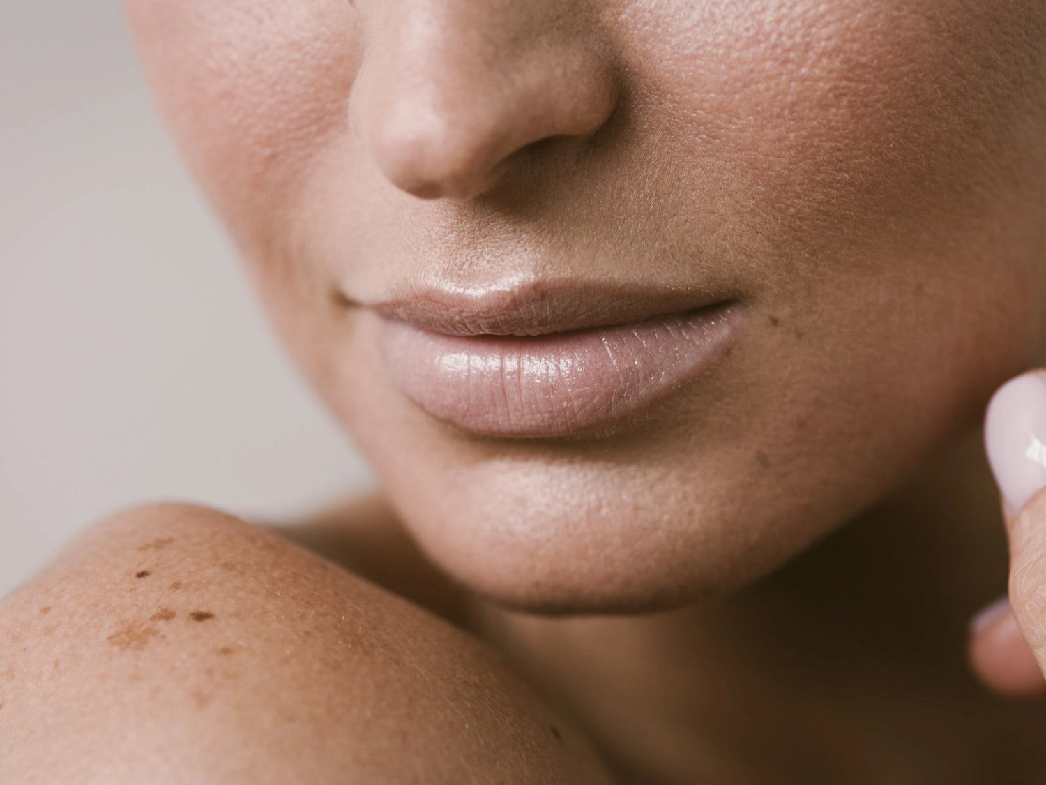 Femme touchant sa joue, illustration d’une peau du visage équilibrée et confortable pour article sur le sérum prébiotique